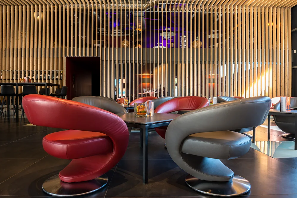 Fauteuils en cuir rouge et gris dans l'espace lounge du Hangar41 à Sion