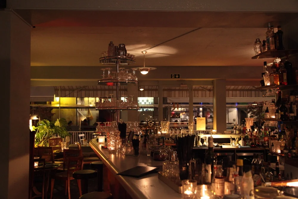 Le Verre à Monique à Genève, le comptoir et les bouteilles à la lueur des bougies