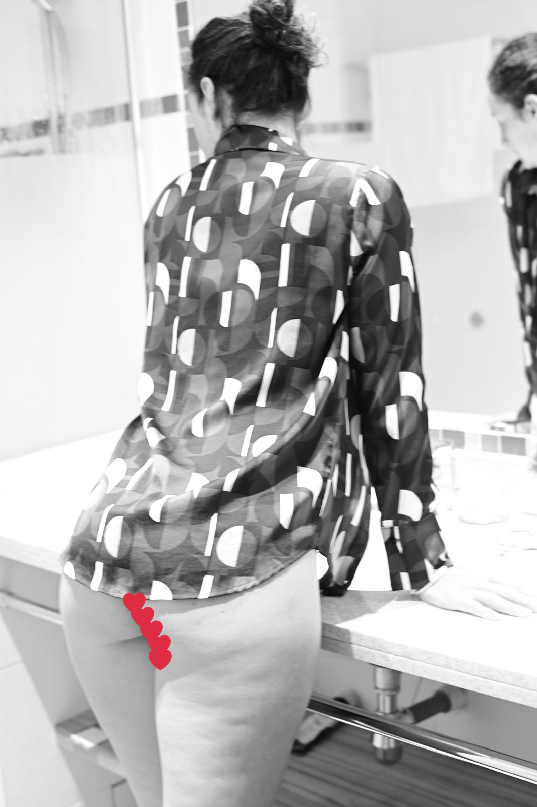 Léna de dos dans une salle de bain, en chemise de soie à motifs, photo en noir et blanc