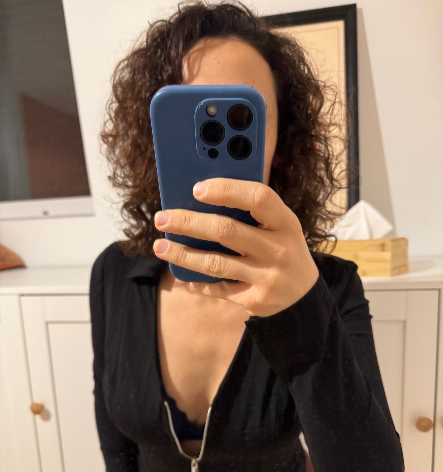 Léna devant le miroir, chemisier noir à fermeture éclair, le Natel devant le visage