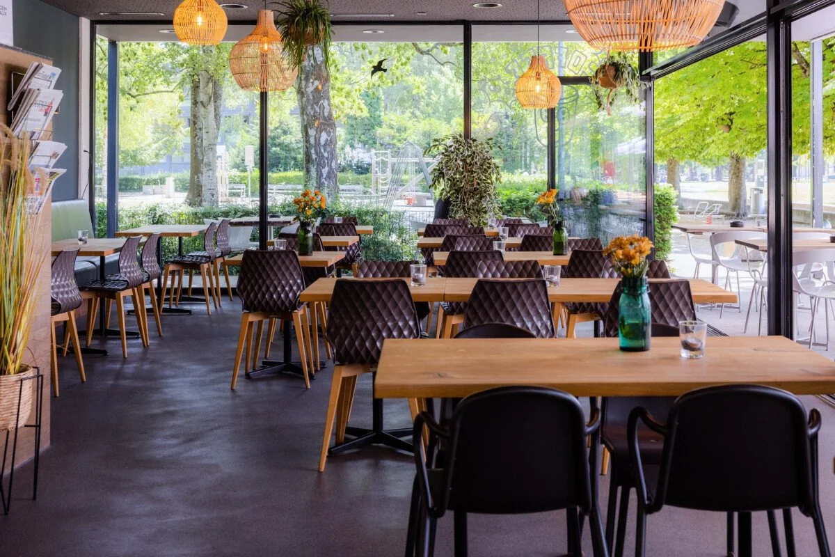 Strandcafé Parasol à Bienne, salle vitrée face aux arbres du Strandboden