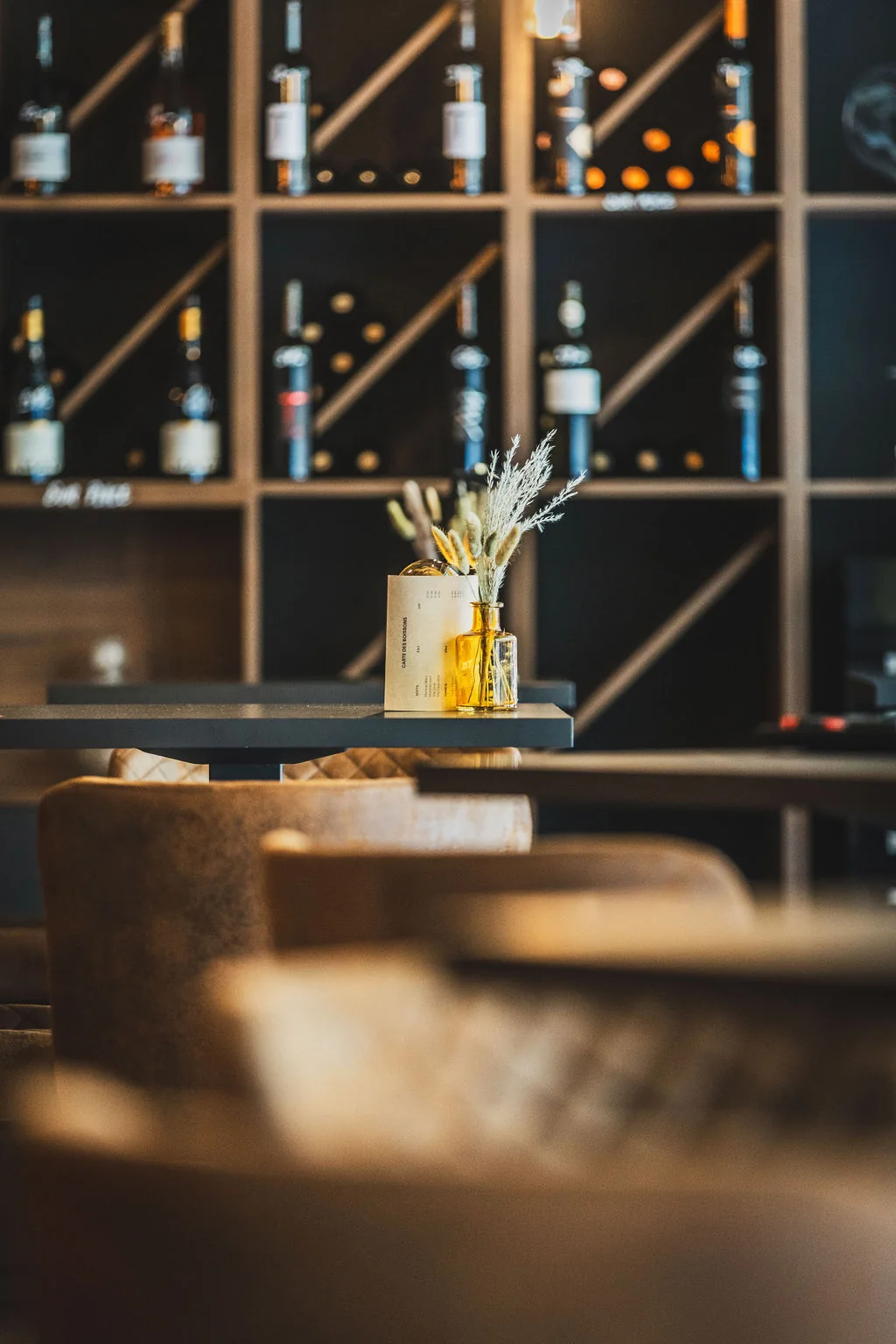 Salle du Pop Bar à Sion, fauteuils en cuir et casiers à vins des encaveurs valaisans